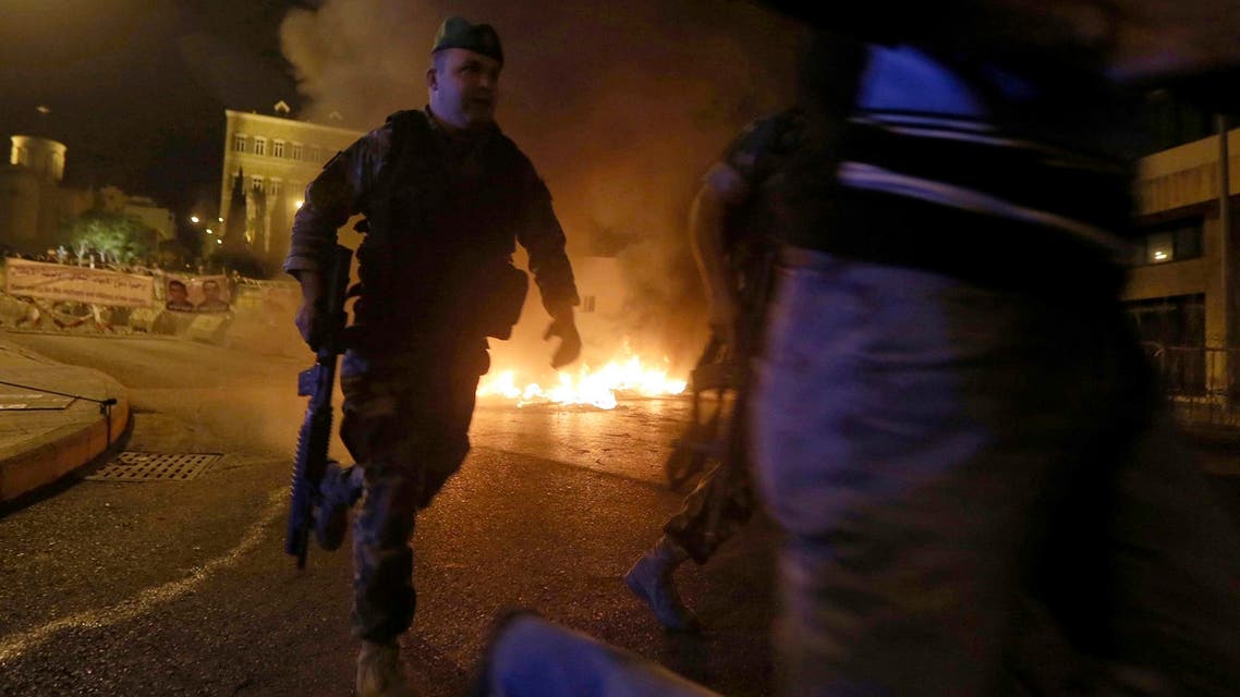 Lebanese Army soldiers run in front of burning tyres during a protest by relatives of soldiers demanding the release of soldiers captured by Islamist militants in Arsal. (AFP)