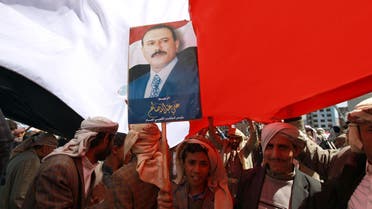 A young supporter of Yemen's former president Ali Abdullah Saleh holds a portrait of him during a rally on Nov. 7, 2014 in Tahrir Square in the capital Sanaa. (AFP)