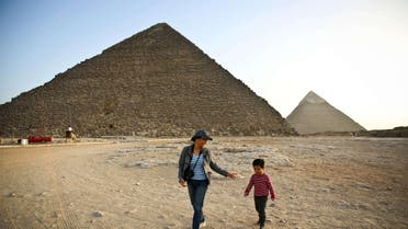  A picture taken on November 9, 2014, shows tourists walking past the pyramids of Menkaure (L) and Khafre (R) in Giza, on the outskirts of Cairo. (AFP)