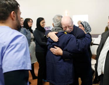 Ed Kassig is greeted by a mourner during a prayer service in memory of his son Abdul-Rahman Kassig, whose name was Peter before his conversion to Islam, in Fishers, Indiana, November 21, 2014. The parents of an American aid worker beheaded by Islamic State militants after his abduction in Syria attended a Muslim prayer service held in their son's honor in Indiana. Kassig was the fifth European or American captive killed by the militants. His severed head was seen in a video that was released on November 16 and also showed the beheadings of at least 14 men. REUTERS/Chris Bergin (UNITED STATES - Tags: OBITUARY POLITICS)