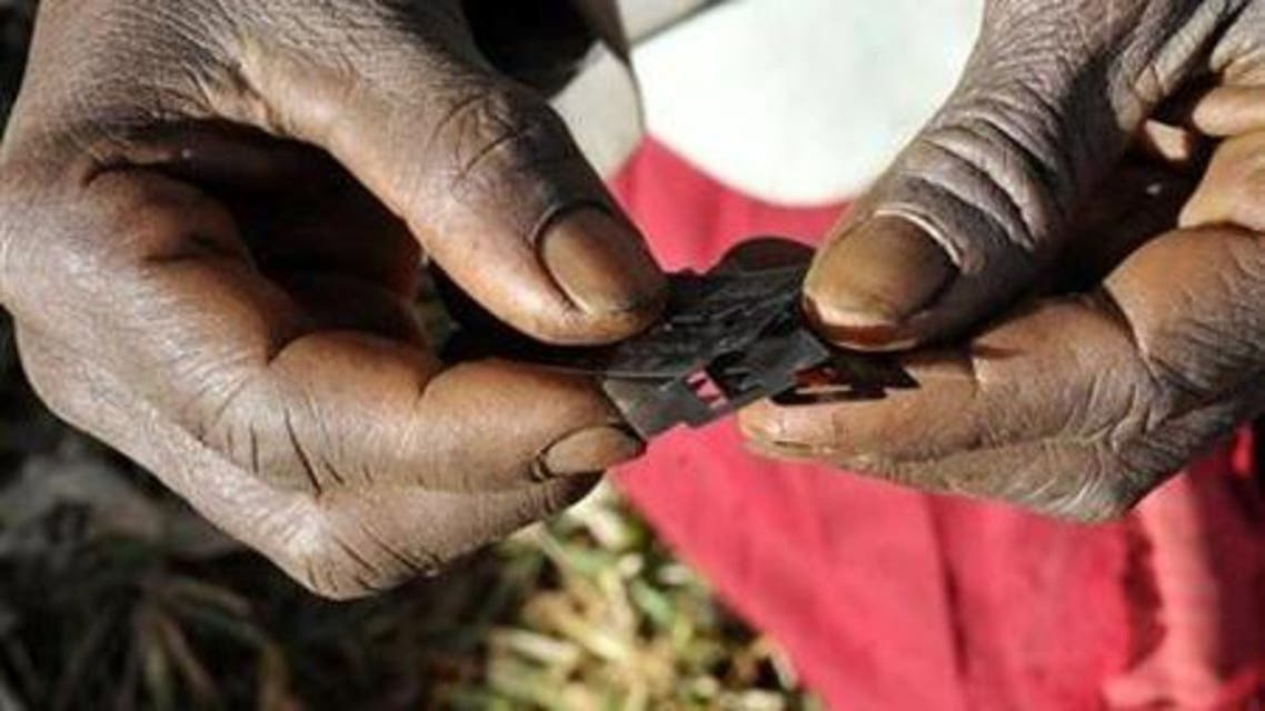Prisca Korein, a 62-year-old traditional surgeon, holds razor blades before carrying out female genital mutilation on teenage girls from the Sebei tribe in Bukwa district, about 357 kms (214 miles) northeast of Kampala, December 15, 2008.