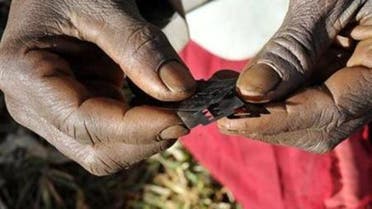 Prisca Korein, a 62-year-old traditional surgeon, holds razor blades before carrying out female genital mutilation on teenage girls from the Sebei tribe in Bukwa district, about 357 kms (214 miles) northeast of Kampala, December 15, 2008. 
