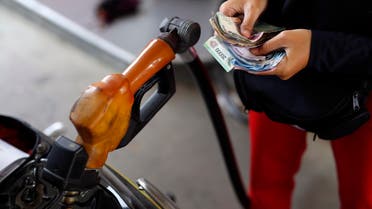 A worker at a state-owned Pertamina petrol station holds money as a motorcycle is filled with subsidised fuel in Jakarta October 31, 2014. Indonesia's new government will make changes to its costly gasoline and diesel subsidies before the end of the year, the country's chief economics minister said on Thursday. An advisor to President Joko Widodo, who was sworn in on Oct. 20, told Reuters earlier this month that a fuel price hike of 3,000 rupiah was planned by the new government, possibly as early as Nov. 1. REUTERS/Darren Whiteside (INDONESIA - Tags: POLITICS ENERGY BUSINESS)