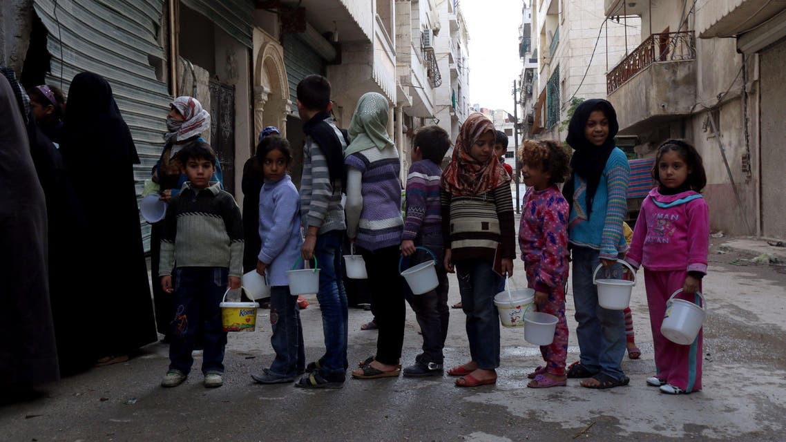 -, SYRIA : Syrian children queue up to receive food aid from a community kitchen that caters for impoverished families in the neighbourhood in the Myassar district of the northern city of Aleppo on November 23, 2014. In recent months, government forces have advanced around the outskirts of the eastern portion of the city that is under rebel control, threatening to encircle it completely. AFP PHOTO / ZEIN AL-RIFAI