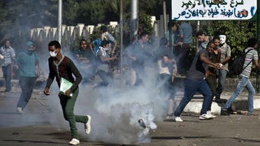 Egyptian students of al-Azhar university run for cover from a tear gas canister fired by riot police during clashes outside their university campus in Cairo AFP 