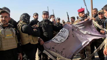 Iraqi Shiite fighters hold an Islamist State flag, which they pulled down from the frontlines after taking control of Saadiya in Diyala province from Islamist State militants, November 24, 2014. (Reuters)