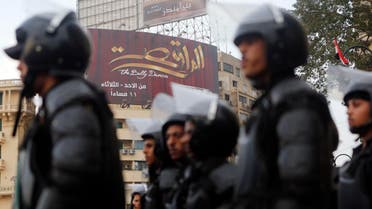 Riot police take their positions in front of a billboard for "The Belly Dancer" television program on the third anniversary of the Mohamed Mahmoud street violence and deadly clashes at Tahrir Square in Cairo Nov. 19, 2014. (Reuters)