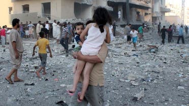 A man carries two children away from the scene of an August 7 explosion in the northern Syrian city of Raqqa. Reuters 