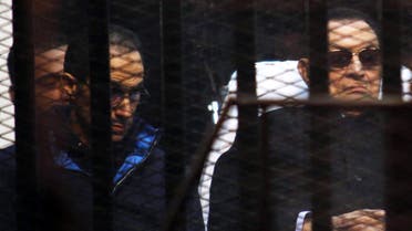 Former Egyptian President Hosni Mubarak listens next to his son Gamal (L) inside a dock during his trial at the police academy on the outskirts of Cairo November 29, 2014. (Reuters)