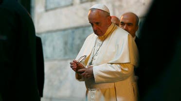 Pope Francis puts away his reading glasses after signing the guest book inside the Saint Sophia Musem during his visit to Istanbul November 29, 2014. (Reuters)