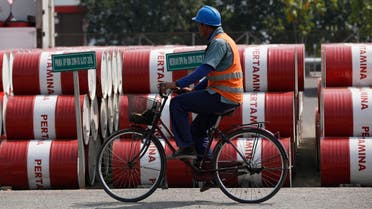 An employee rides his bike past barrels of petroleum products at a state-owned Pertamina fuel depot in Jakarta September 9, 2014. (Reuters)