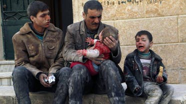 A man holds a baby saved from under rubble, who survived what activists say was an air strike by forces loyal to Syrian President Bashar al-Assad, in Masaken Hanano in Aleppo, in this February 14, 2014