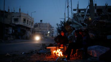 Palestinians warm themselves by a fire near the ruins of houses which witnesses said were destroyed by Israeli shelling during the most recent conflict between Israel and Hamas, in the east of Gaza City. (File photo: Reuters)