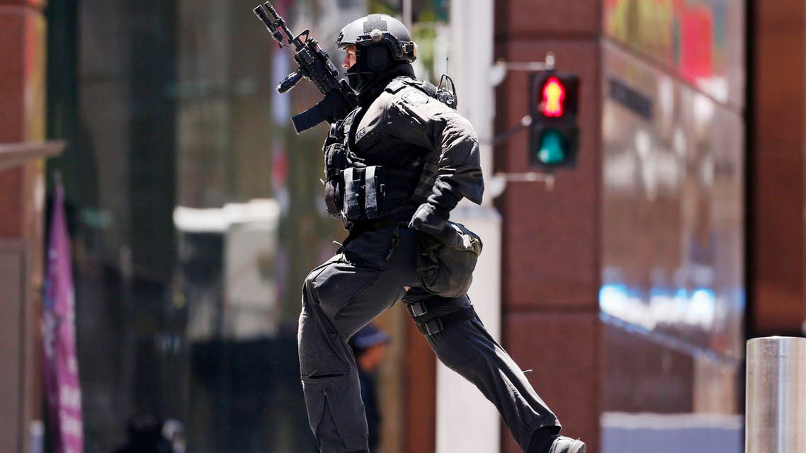 A police officer runs across Martin Place near Lindt cafe, where hostages are being held, in central Sydney December 15, 2014. (Reuters)