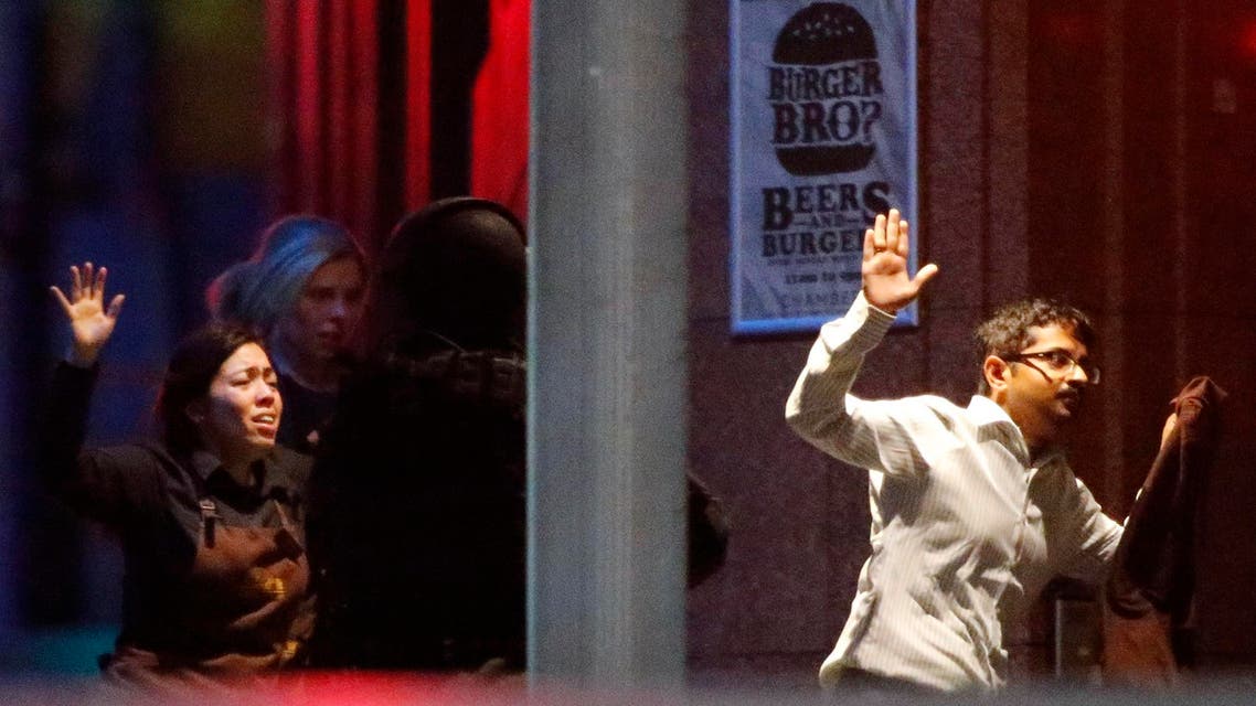 Hostages run past a police officer (C) near Lindt Cafe, at Martin Place in central Sydney December 16, 2014. (Reuters)