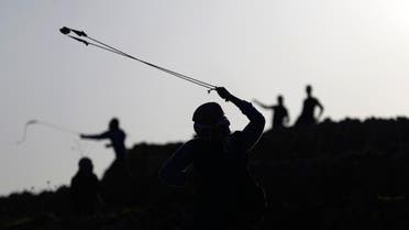A Palestinian protester uses a slingshot to throw stones at Israeli troops during clashes near Israel's Ofer Prison, near the West Bank city of Ramallah December 13, 2014.  (Reuters)