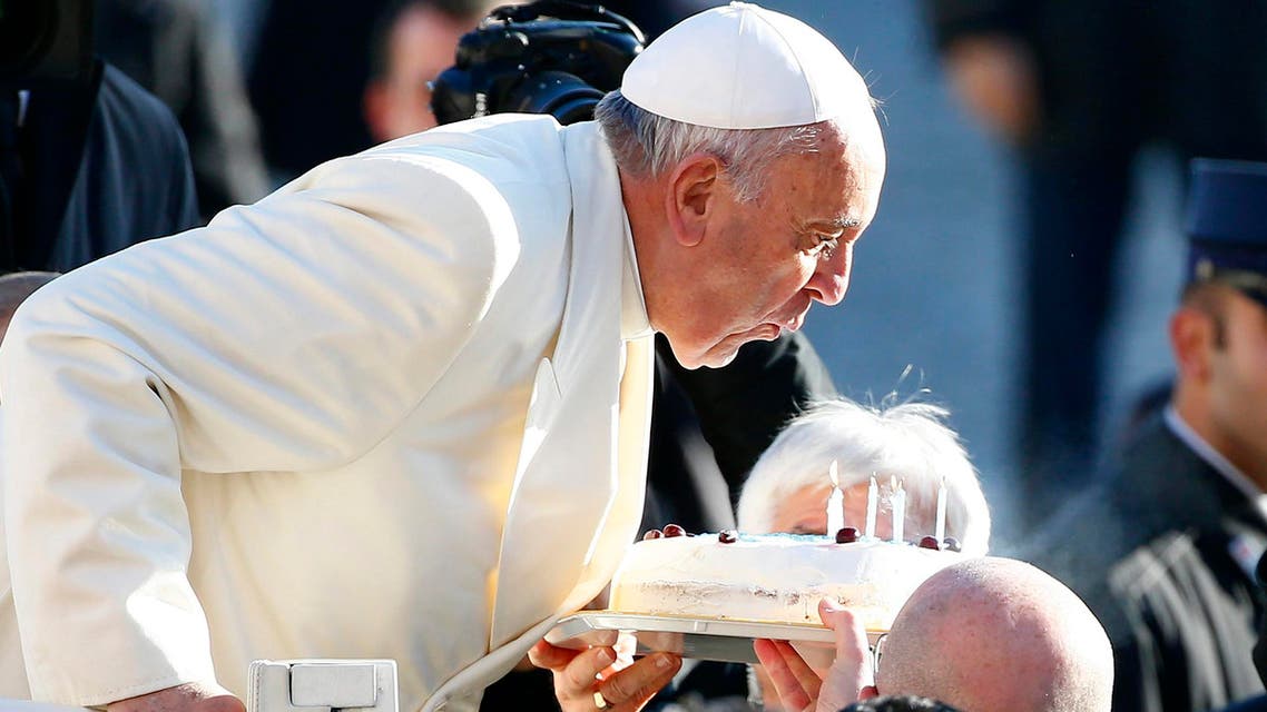 Pope Francis, who's 78th birthday is today, blows out candles on a cake as he arrives to lead his general audience at the Vatican, December 17, 2014. (Reuters)