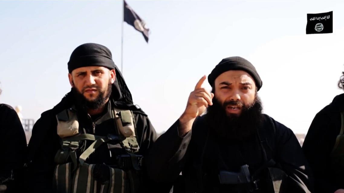 An ISIS militant wanted by Tunisian authorities for murder speaking next to fellow militants from an undisclosed location under the extremist group's control and claiming the 2013 twin assassinations of Chokri Belaid and Mohamed Brahmi. (Screengrab)