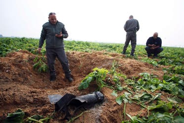 Israeli security forces stand next to the remains of a rocket that was fired from the Gaza Strip towards Israel on Friday, on the Israeli side of the border December 19, 2014. reuters