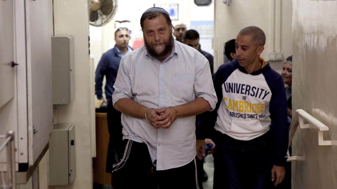 Israeli settler Benzi Gopstein, the leader of the extreme right-wing movement Lehava, is escorted out of a hearing at a Jerusalem court on December 18, 2014. (File photo: AFP)