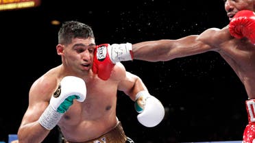 Welterweight boxer Amir Khan (L) of Britain takes a punch from Devon Alexander of the U.S. during a welterweight fight at the MGM Grand Garden Arena in Las Vegas, Nevada December 13, 2014. (Reuters)