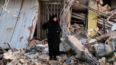 A woman looks at damages at the site of a car bomb attack in Baghdad's Sadr City , December 5, 2014. Reuters