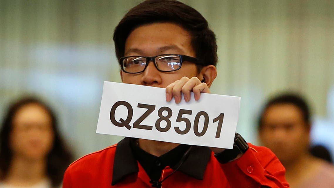 A Changi Airport staff holds up a sign to direct possible next-of-kins of passengers of AirAsia flight QZ 8501 from Indonesian city of Surabaya to Singapore, at Changi Airport in Singapore December 28, 2014