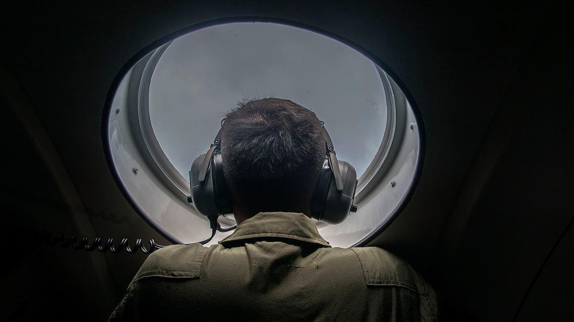 A member of the Indonesian military looks out of the window during a search and rescue (SAR) operation for missing Malaysian air carrier AirAsia flight QZ8501, over the waters of the Java Sea on Dec. 29, 2014.  (AFP)