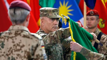 U.S. General John Campbell (C), commander of NATO-led International Security Assistance Force (ISAF), folds the flag of the ISAF during the change of mission ceremony in Kabul, December 28, 2014. 