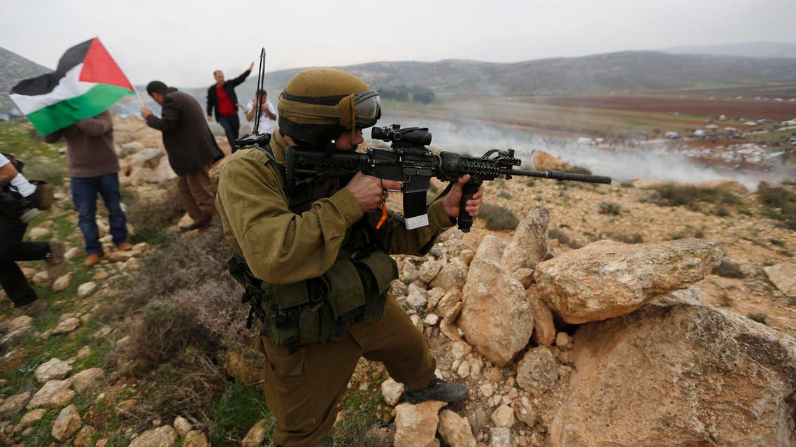 An Israeli soldier aims his weapon during clashes with activists and Palestinian protesters following a demonstration against Israeli settlements in the West Bank village of Turmus Aya, near Ramallah December 19, 2014. (File photo: Reuters)