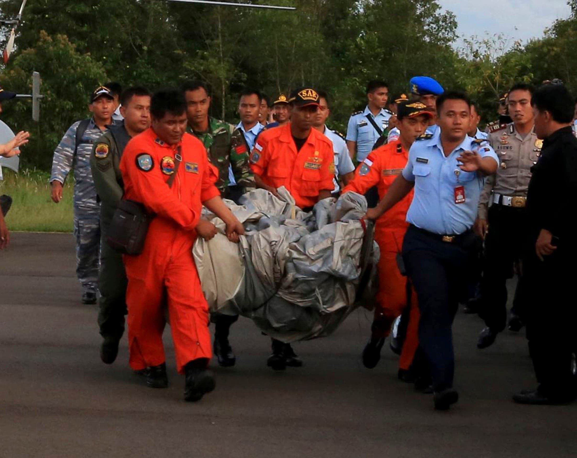 Members of the Search and Rescue Agency carry debris recovered from the sea presumed from missing Indonesia AirAsia flight QZ 8501. (Reuters)