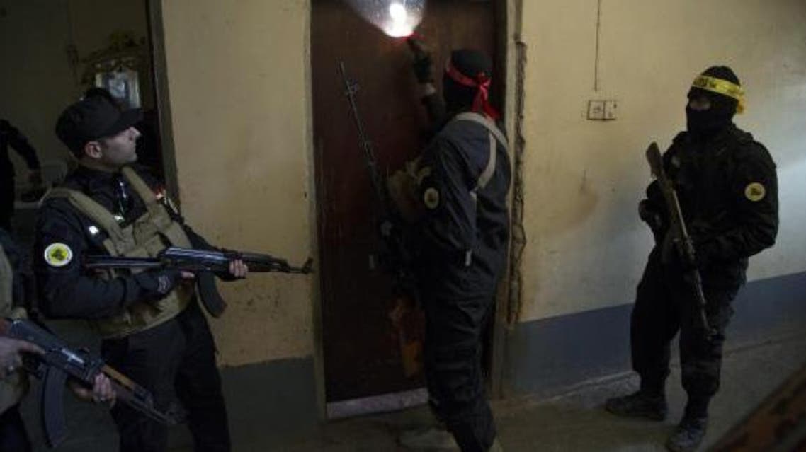 Fighters from the Shi'ite Kata'ib Imam Ali (Imam Ali Brigades) militia search a house after taking control of a village from Islamist State militants, on the outskirts of Dhuluiya, north of Baghdad December 29, 2014. (Reuters)