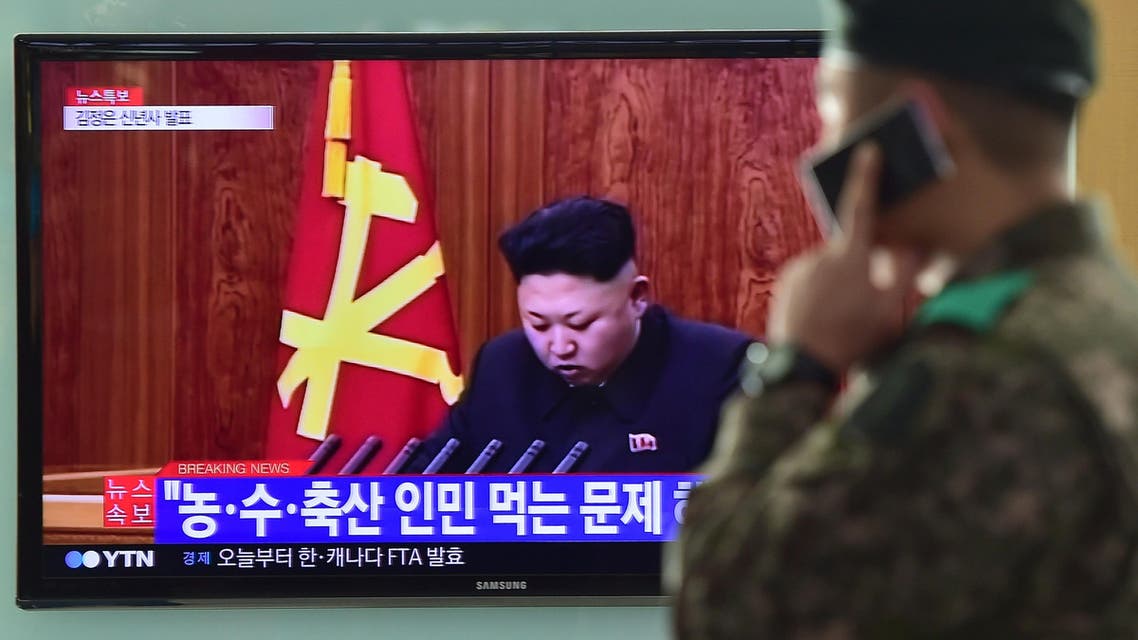 A South Korean soldier talks over his phone in front of a television screen showing North Korean leader Kim Jong-Un's New Year speech, at a railroad station in Seoul on January 1, 2015. AFP