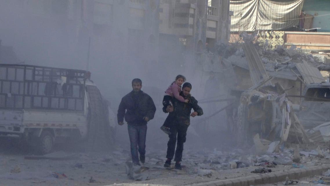 A man carries a girl past damage at a site hit by what activists said was an air strike by forces loyal to Syria's President Bashar al-Assad in the northwestern Homs district of Al Waer Dec. 30, 2014. (Reuters)