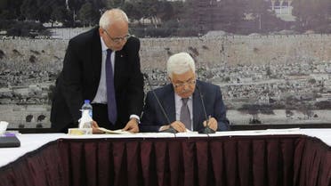 Palestinian President Mahmoud Abbas (R) signs international agreements in the West Bank city of Ramallah, in this Dec. 31, 2014 handout picture. (Reuters)