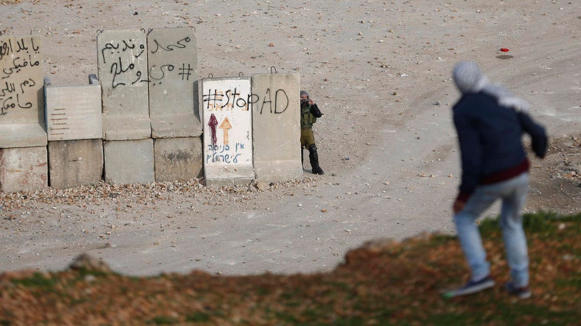An Israeli soldier uses a camera to film Palestinian stone-throwers during clashes near Israel's Ofer Prison, near the West Bank city of Ramallah January 2, 2015. (Reuters)