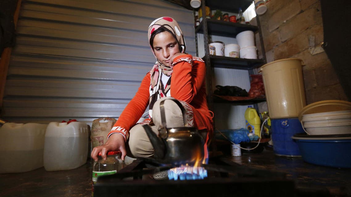 A Syrian refugee girl makes tea inside a caravan at the Al Zaatari refugee camp in the Jordanian city of Mafraq, near the border with Syria, December 7, 2014. reuters