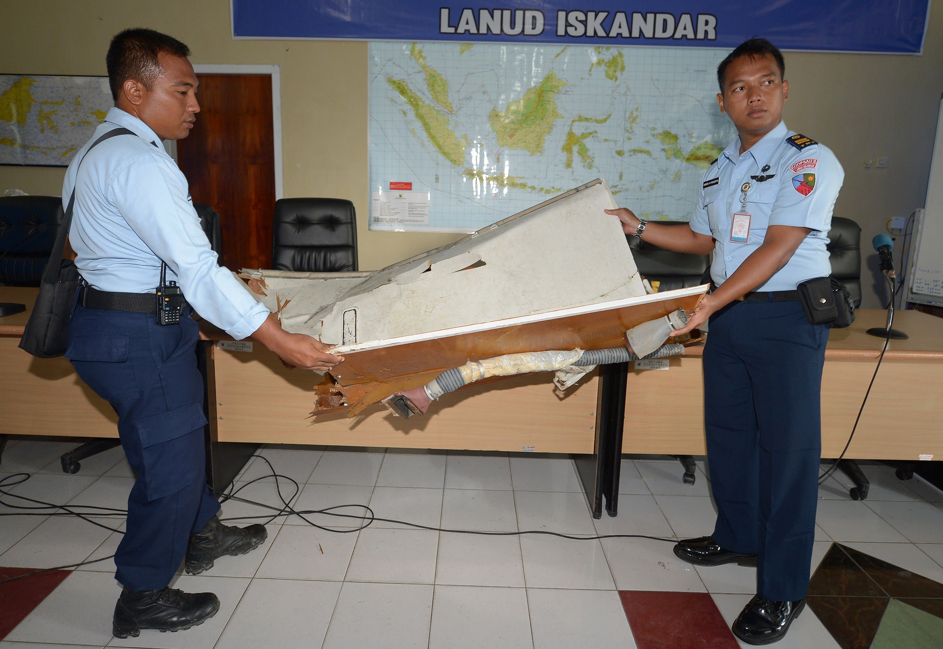Indonesian military officers examine a piece of wreckage from AirAsia flight QZ8501, at the military base in Pangkalan Bun, the town with the nearest airstrip to the crash site, on January 2, 2015. (AFP) Airasia wreckage