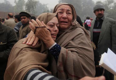 Mother (L) and grandmother of Muhammad Ali Khan, a student who was killed during an attack by Taliban gunmen on Army Public School, mourn during the visit of Imran Khan, chairman of Pakistan Tehrik-e-Insaf (PTI) political party, at the school in Peshawar December 22, 2014.