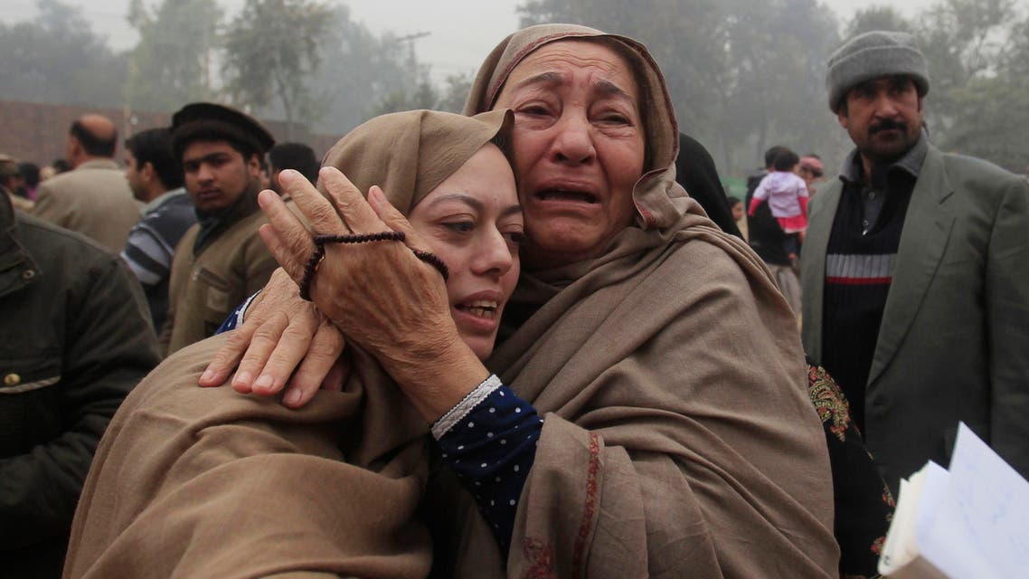Mother (L) and grandmother of Muhammad Ali Khan, a student who was killed during an attack by Taliban gunmen on Army Public School, mourn during the visit of Imran Khan, chairman of Pakistan Tehrik-e-Insaf (PTI) political party, at the school in Peshawar December 22, 2014.