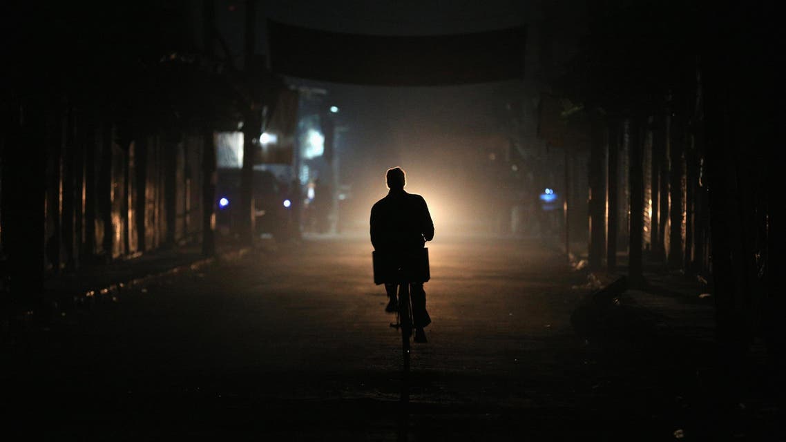 A resident drives a motorbike at night on New Year's Eve in eastern al-Ghouta, near Damascus December 31, 2014. (Reuters)