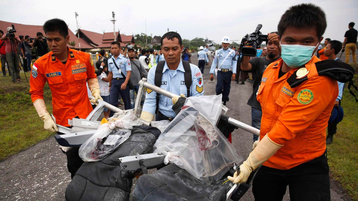 Parts of AirAsia QZ8501, recovered from the Java Sea, are carried by Indonesian Airforce and Search and Rescue crew members after they were offloaded from a U.S. Navy helicopter at the airport in Pangkalan Bun, Central Kalimantan January 5, 2015. (Reuters)