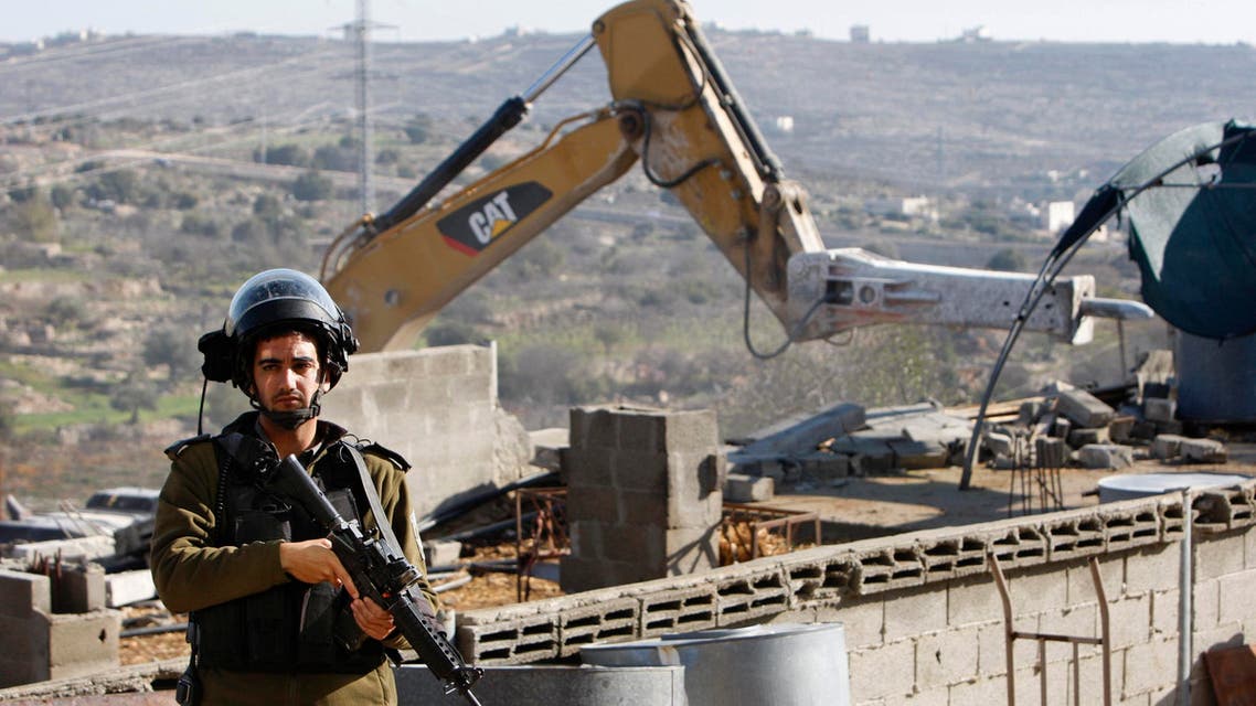 An Israeli policeman stands guard during the demolishing of a stockade owned by Palestinians in the West Bank city of Hebron January 5, 2015. (Reuters)