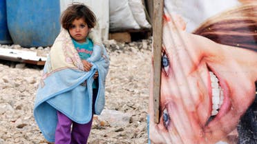 A Syrian refugee girl covers herself with a blanket as she stands outside tents at a makeshift settlement in Bar Elias in the Bekaa valley January 5, 2015. (Reuters)