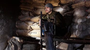 A Free Syrian Army fighter sits behind sandbags in Jobar, a suburb of Damascus Jan. 4, 2015.  (Reuters)