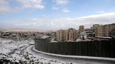 Snowfall is seen around a section of the controversial Israeli barrier that runs along the Shuafat refugee camp in the West Bank near Jerusalem January 8, 2015. (Reuters)