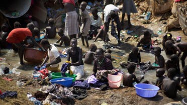 displaced people bathe and wash clothes in a stream inside a United Nations compound which has become home to thousands of people displaced by the recent fighting, in Juba, South Sudan. (File photo: AP)