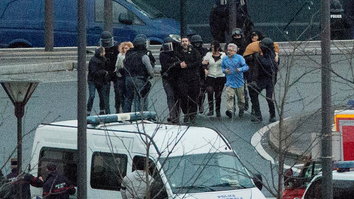 Security officers escort released hostages after they stormed a kosher market to end a hostage situation, Paris, Friday, Jan. 9, 2015. (AP)
