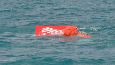 Part of the tail of AirAsia QZ8501 floats on the surface after being lifted as Indonesian navy divers conduct search operations for the black box flight recorders and passengers and crew of the aircraft, in the Java Sea January 10, 2015. (Reuters)