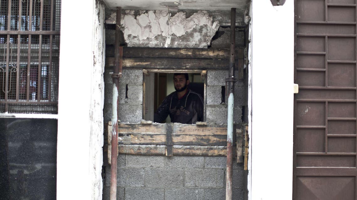 A Palestinian worker looks at the damage the day after an explosion targeting the Bank of Palestine, which destroyed the ATM, in Gaza City on January 10, 2015. AFP